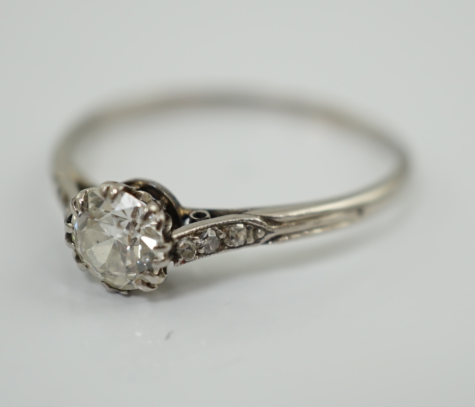 A platinum? and single stone diamond set ring, with six stone diamond chip set shoulders